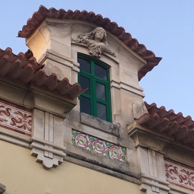 Random house in the streets of the town of Aveiro, Portugal. Its main attractions are the tiles showing some flowers and a sculpture of a young woman's face