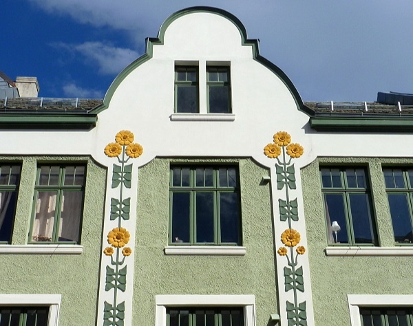 Cute yellow flowers on the façade of an art nouveau Alesund green building