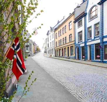 Norwegian flag in a street of Alesund, Norway, in a image with no cars and no people. A very quiet street