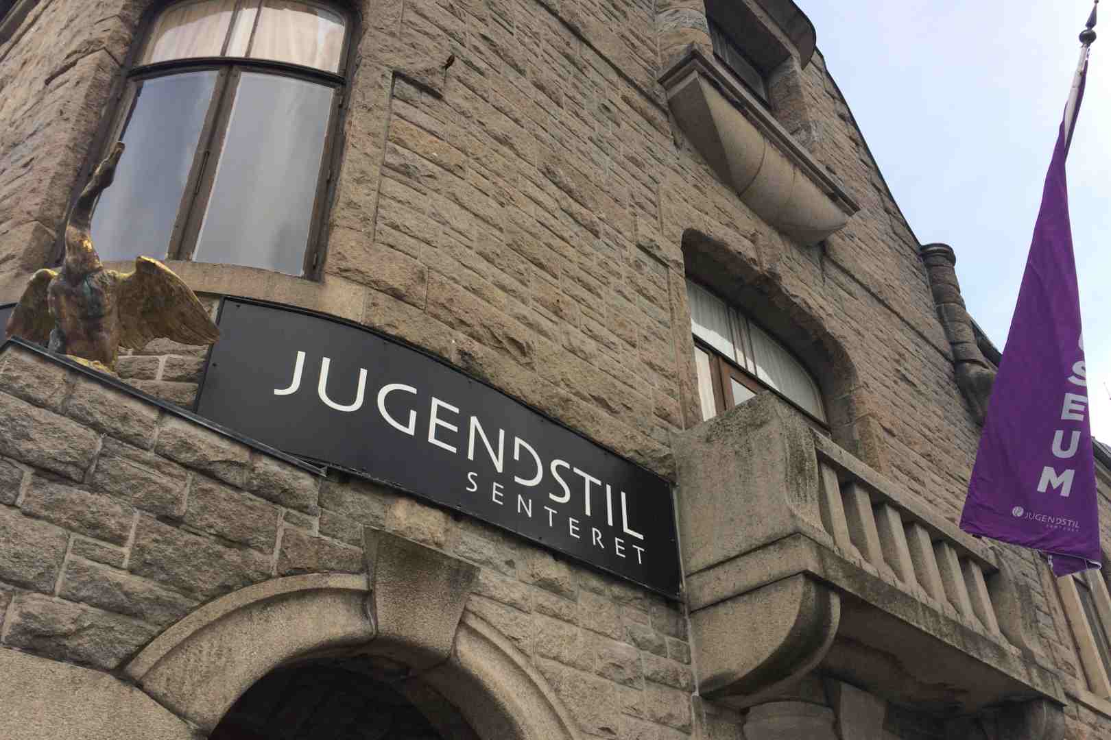 Museum entrance sign and pink flag on the entrance of the Jugendstil museum in the centre of Alesund at sunset