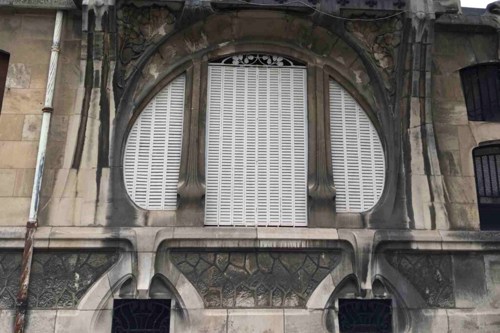 Very large round window in an old art nouveau building in the center of Nancy, France.