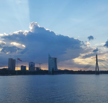 View of Riga landscape, with the Latvian flag and a sunset.